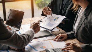 Businessman and team analyzing financial statement Finance task. with smart phone and laptop and  tablet. Wealth management concept at office